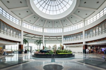 Spacious atrium with a glass dome ceiling, central indoor garden, and expert flooring by a leading commercial flooring company.