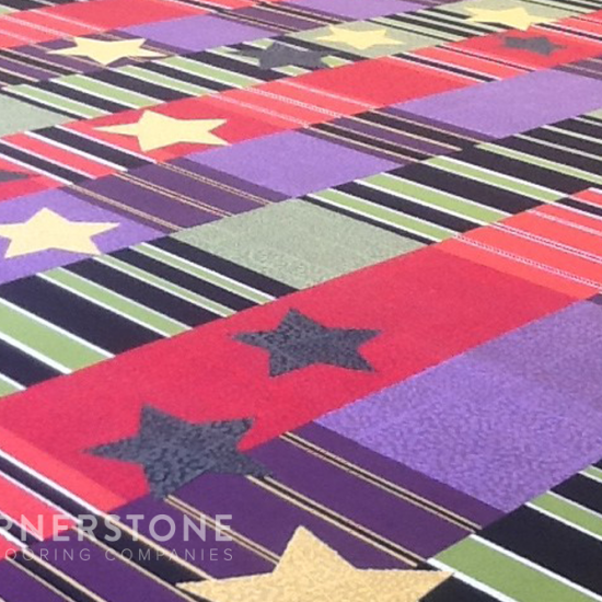 Patterned carpet with horizontal stripes and scattered stars, by a trusted apartment flooring company. “Cornerstone Flooring Companies” is visible.
