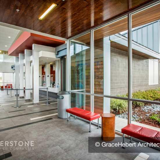 Modern building interior with large windows, red benches, and gray tile floors by a leading commercial flooring company.