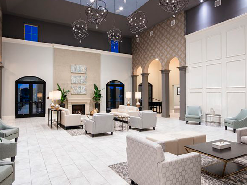 Spacious modern lounge with sofas, chandeliers, decorative walls, large windows, and tiled flooring by an expert flooring installation company.
