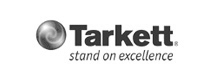 Tarkett logo with a circular swirl icon and the tagline "stand on excellence"—a leading commercial flooring company.